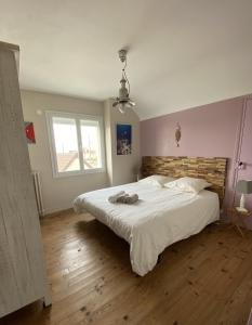 una camera con un grande letto e una finestra di La Maison des phares a Lion-sur-Mer