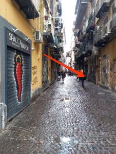un callejón con una cinta roja en una calle en Spaccanapoli house en Nápoles