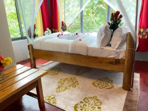 a bedroom with a canopy bed with a window at MISE CAVE LODGE in Kapchorwa