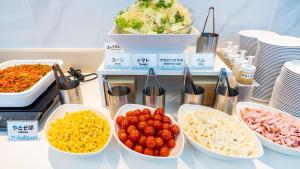 a table topped with bowls of different types of food at Toyoko Inn Gotemba Ekimae in Gotemba