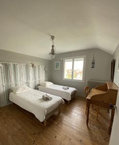 1 dormitorio con 2 camas y piano en La Maison des phares, en Lion-sur-Mer