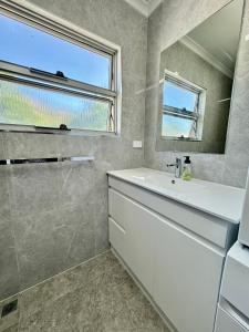 baño con lavabo blanco y ventana en Townsville Apartment on Paxton - First Floor, en Townsville