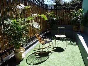 a patio with a chair and a table and plants at Nomadia Hostel Boutique in Bogotá