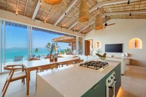 a kitchen and dining room with a view of the ocean at Bohemian Chic Seaview Villa in Koh Samui 
