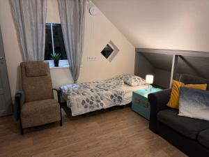 um pequeno quarto com uma cama e uma cadeira em Penthouse in Kohila em Kohila