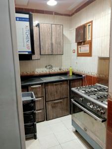 a kitchen with wooden cabinets and a stove at شقة فندقية في بورسعيد in Port Said