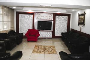 a waiting room with a red chair and a flat screen tv at Yeni Kosk Esra Hotel in Konya