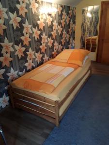 a bed in a bedroom with flowers on the wall at Kleines Haus am Wald in Rohrbach