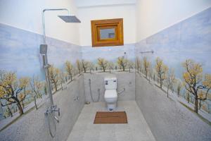 Ella Sriya Holiday Resort في إيلا: حمام به مرحاض وأشجار مرسومة على الحائط