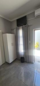 um quarto com armários brancos e uma grande janela em Abay Lodge em Durban
