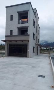 a large gray building with a large parking lot at 21 Tao Heung Homestay in Jiaoxi