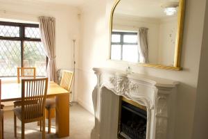 a living room with a fireplace and a table and a mirror at Entire Private House In Chalkwell (Southend) Amazing Sea Views in Southend-on-Sea