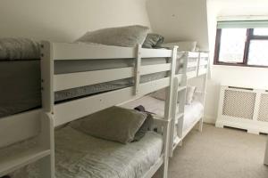 two white bunk beds in a room with a window at Entire Private House In Chalkwell (Southend) Amazing Sea Views in Southend-on-Sea