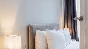 a bed with white pillows next to a window at Coastal Escape close to North Bay- Pet Friendly in Scarborough