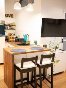 a kitchen with a counter with two chairs around it at Modern Cosy Studio in Ivry-sur-Seine