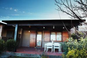 una mesa y sillas en el porche de una casa en Rilassante Villetta Marittima, en Stintino