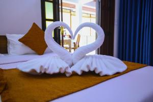 two swans made out of towels on a bed at Ella Sriya Holiday Resort in Ella