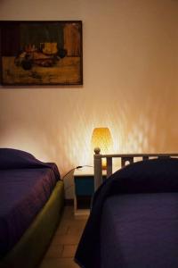 Un dormitorio con dos camas y una mesa con lámpara. en Rilassante Villetta Marittima, en Stintino