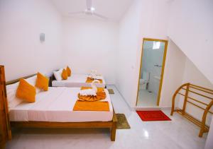 1 dormitorio con 2 camas y baño en Ella Sriya Holiday Resort, en Ella