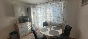 una cocina con una mesa y sillas blancas y una ventana en Sweet Home, en Wermelskirchen