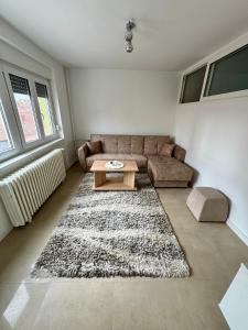 a living room with a couch and a table at Apartman Nest in Kikinda