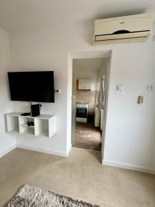 a living room with a flat screen tv on a wall at Apartman Nest in Kikinda