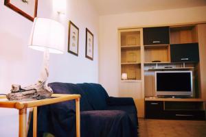 sala de estar con sofá azul y lámpara en Rilassante Villetta Marittima, en Stintino