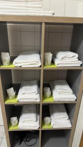 a shelf filled with white towels in a bathroom at Zum Zacherwirt in Hengersberg