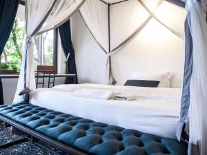a bedroom with a bed with a blue bench at Explorers Hub in Kampala