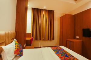 a hotel room with a bed and a window at FabHotel Prime Swarn Bhoomi in Kānpur