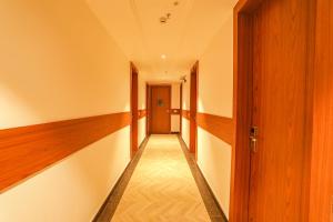 an empty hallway with a door and wooden floors at FabHotel Prime Swarn Bhoomi in Kānpur