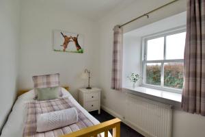 um quarto com uma cama e uma janela em Normanns Ruh em Ballygown