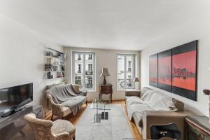 a living room with a couch and a tv at Charme et authenticité à Montmartre by Weekome in Paris