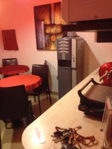 una cocina con 2 mesas y 2 sillas y una barra en MagloInnFiera en Bolonia