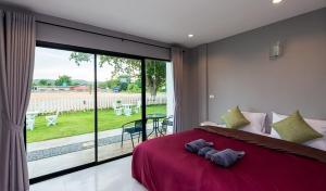 a bedroom with a red bed and a large window at Kodtalay Resort in Chao Lao Beach