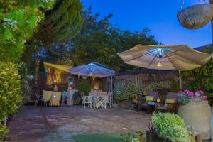 a patio with two umbrellas and tables and chairs at Abad casa Siguenza 250m2 vivienda y exterior in Sigüenza