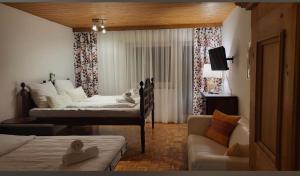 a hotel room with two beds and a couch at Haus Wenger Mountain View & Swimming Pool in Kaprun