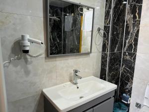 y baño con lavabo y espejo. en world say hotel, en Bostaniçi