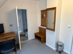 a room with a desk and a mirror and a bathroom at Hotel Auri in Rudník