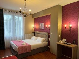 レ・サ​​ーブル・ドロンヌにあるHôtel Calme Des Pins & Spaのピンクの壁のベッドが備わるホテルルームです。