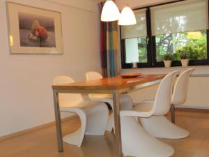 ein Esszimmer mit einem Holztisch und weißen Stühlen in der Unterkunft Landhaus zur Linde in Winterberg