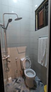 a bathroom with a toilet and a shower at Rest Inn Lounge & Lodge in Dar es Salaam