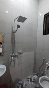 a bathroom with a shower and a toilet and a sink at Rest Inn Lounge & Lodge in Dar es Salaam