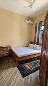 a bedroom with a large bed and a desk at Rest Inn Lounge & Lodge in Dar es Salaam