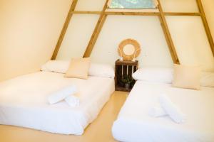 Duas camas num quarto com uma janela em Kampaoh Ruiloba em Liandres