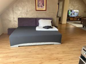een groot bed in een kamer met een houten vloer bij Apartmán 301 VOLT in Nové Zámky