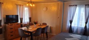 Habitación con mesa con sillas y TV. en Tiny House Valea Avrigului en Avrig
