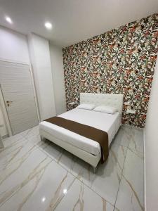 a bedroom with a bed and a floral wall at Life Hotel in Casalnuovo di Napoli