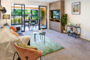 a living room with a couch and a table at Cozy 1-Bed Apartment with Park Views, Sleeps 4 in Christchurch