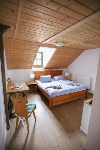 a bedroom with a bed and a wooden ceiling at Penzion Na Gruntu in Lipná